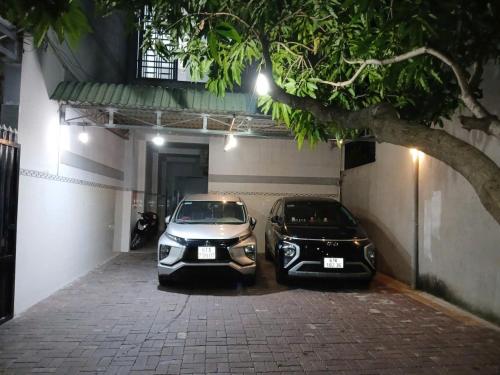 two cars are parked in a parking lot at Thiên Thanh Long Hải Motel in Long Hai