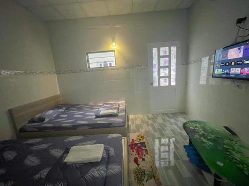 una piccola stanza con due letti e una televisione di Thiên Thanh Long Hải Motel a Long Hai