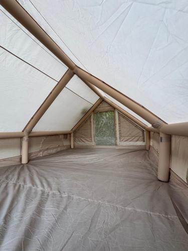 une grande tente blanche avec une fenêtre. dans l'établissement Moorea camping Valley, à Moorea