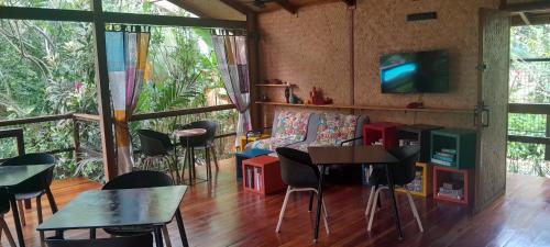 a living room with tables and chairs and a tv at At Home in Puerto Princesa City