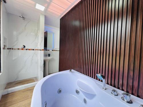 巴尼奥斯Luxury Apartment with Jacuzzi 2 Bedroom 2 Bath的带淋浴的浴室里的白色浴缸