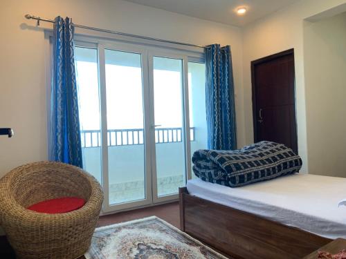 a bedroom with a bed and a large window at Begonia Homestay Darjeeling in Darjeeling