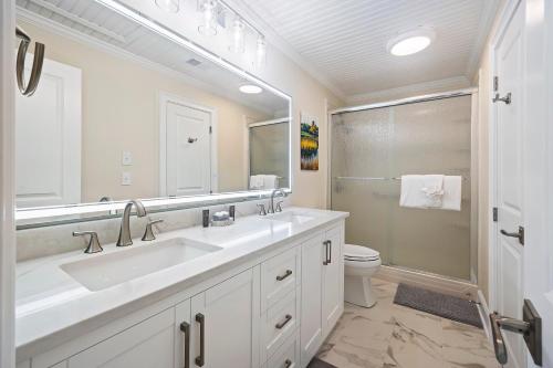 a bathroom with a sink and a toilet and a mirror at CA411: 411 Carolina Blvd. in Isle of Palms