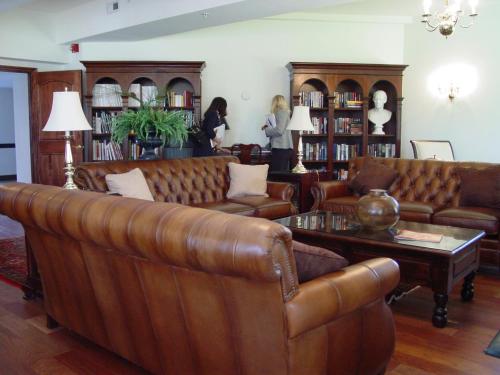 a living room with brown leather couches and a table at Wedmore Place in Williamsburg