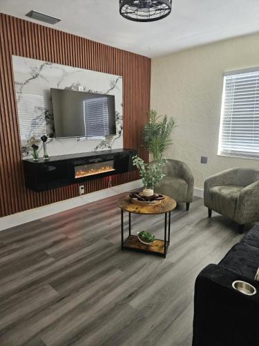 a living room with a tv and a table at Palmera House in Tampa with Hot Tub 10 minutes from Airport & Busch Gardens in Tampa
