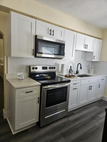 a kitchen with white cabinets and a stove top oven at Palmera House in Tampa with Hot Tub 10 minutes from Airport & Busch Gardens in Tampa