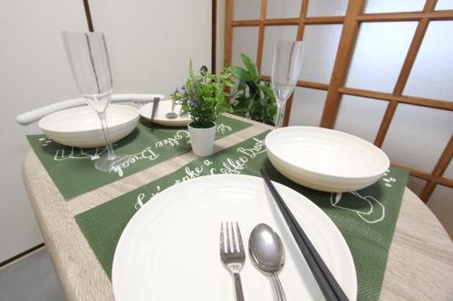 a table with white plates and silverware on a table at HOTEL LUANA in IKEBUKURO HIGASHINAGASAKI in Tokyo