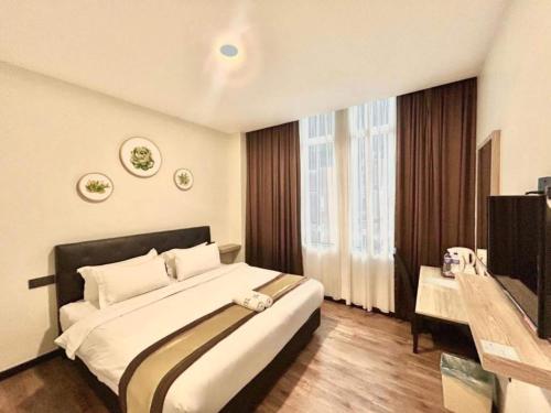 a bedroom with a large bed and a television at Collection O Malacca Near St John's Fort Formerly Gill Garden in Melaka