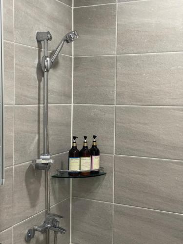 three bottles of wine sitting on a shelf in a shower at 뚠하우스3 in Samgong