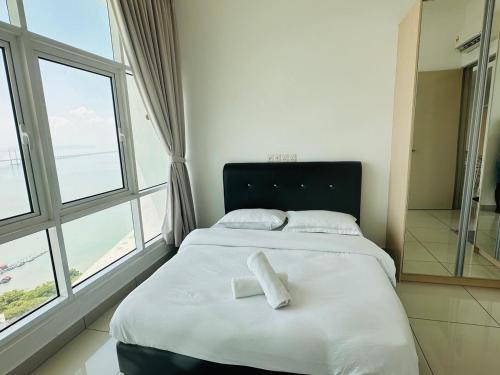 a bedroom with a bed with two white towels on it at Seaview Condo A31 #Queensbay#SPICE in Bayan Lepas