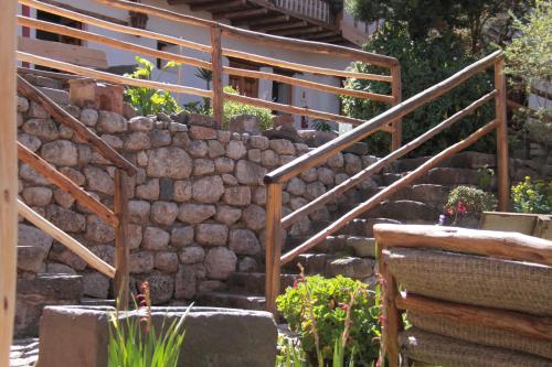 a stone staircase with a stone wall and wooden railing at El Balcón in Cusco