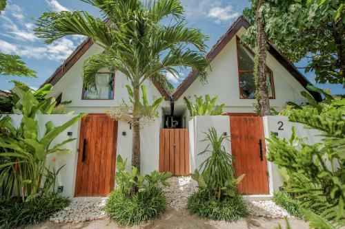 una casa con puertas de madera y palmeras en THE LOFT - Super Central General Luna, en General Luna