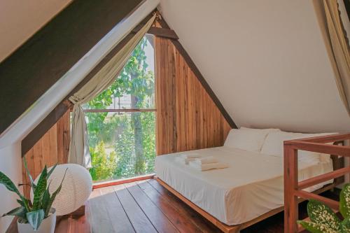 a bedroom with a bed and a large window at THE LOFT - Super Central General Luna in General Luna