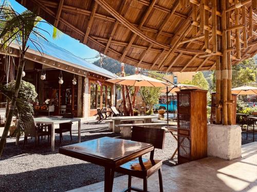 a patio with tables and chairs and umbrellas at Cicada Lanta in Ko Lanta