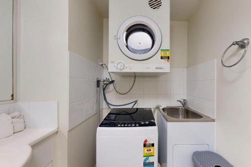 a small kitchen with a stove and a sink at Sweet Mango Hill Apartment w Convenient Location in North Lakes