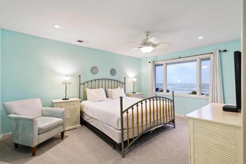 a bedroom with a bed and a chair and a window at SG3C: 3C Seagrove Villa in Isle of Palms