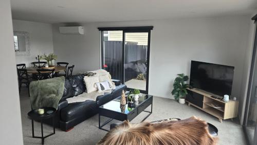 a living room with a couch and a tv at The Park Premium 2 Bedroom Apartment in Christchurch