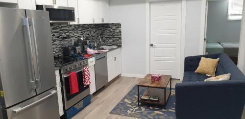 a kitchen with a stove and a blue couch at Executive 1Bedroom Suite By Henday in Edmonton