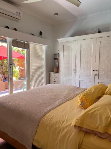 Un dormitorio con una cama grande con almohadas amarillas. en Villa Harmony Moon, en Denpasar