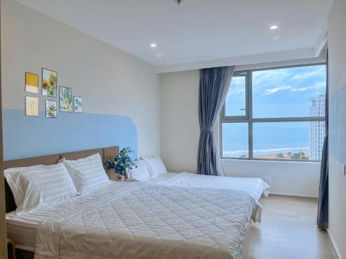 a bedroom with a large bed and a large window at Căn Hộ The Sóng Condotel Vũng Tàu - Hao'sHomestay in Vung Tau