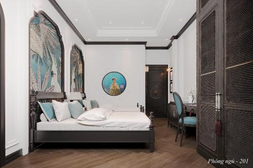 a bedroom with a bed with a painting on the wall at Indocharm Villa Cat Ba in Cat Ba