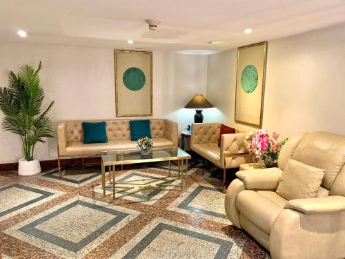 a living room with two couches and a table at City Lodge Bangkok in Bangkok