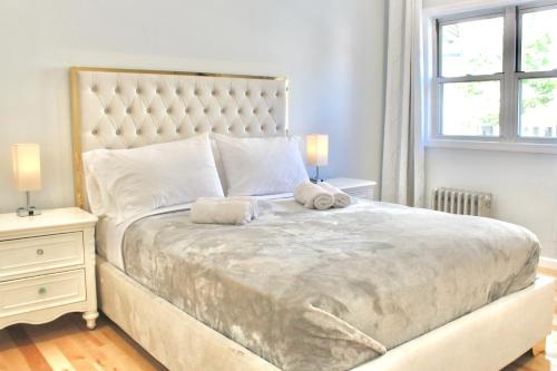 a bedroom with a large bed with two stuffed animals on it at 2-Bedroom Apartment 15 Minutes From Manhattan in LIC Astoria Queens 