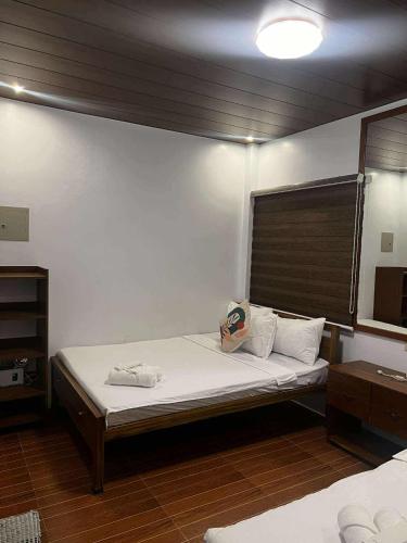 a bedroom with a large bed with white sheets at BALAI MALINAWON Hotel 3 in General Luna