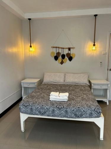 a bedroom with a bed with two tables and two lights at Kuya and Kambal's 1 BR 1 Bath Apartment in Manila