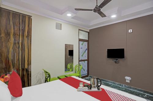 a room with two tables and a tv on the wall at Hotel O Metro Inn in Noida