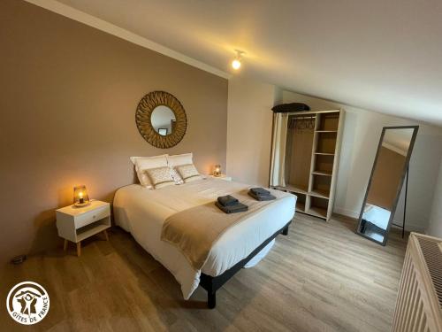 a bedroom with a large bed and a mirror at Maison familiale avec babyfoot et piscine chauffée - FR-1-426-597 in Soullans