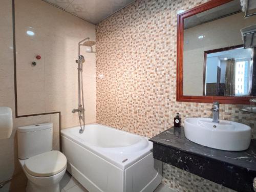 a bathroom with a toilet and a sink and a tub at Minh Châu Hotel in Kon Rung (1)