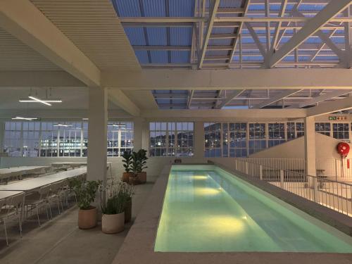 a swimming pool in a building with a large ceiling at BlackBrick Gardens in Cape Town