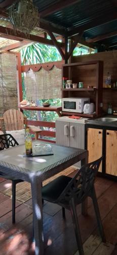 uma cozinha com uma mesa e uma mesa e um balcão em Bungalow atypique Ti Mabouya à 500m de la plage em Sainte-Anne