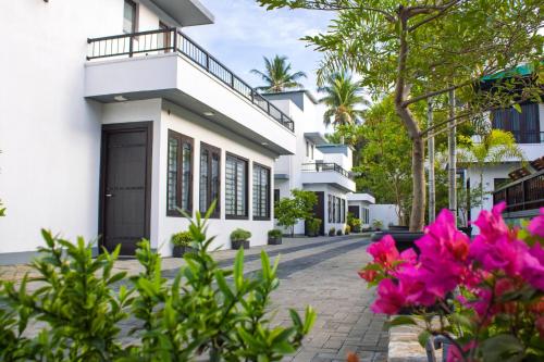 a white house with pink flowers in front of it at Breedon Residence Hotel in Anuradhapura