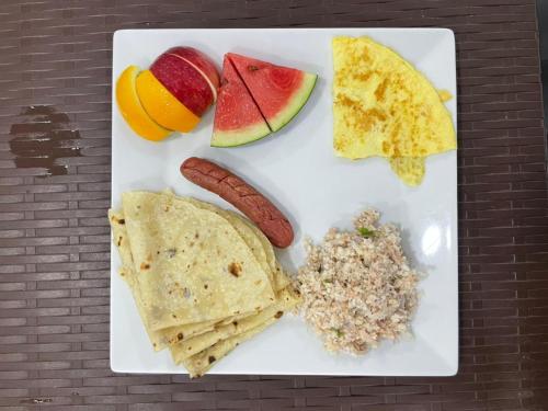 ein weißer Teller mit Frühstückszutaten auf dem Tisch in der Unterkunft Wish Maamigili in Maamigili