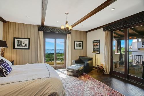 een slaapkamer met een bed en een stoel en een balkon bij Ocean View Villa in Santa Barbara