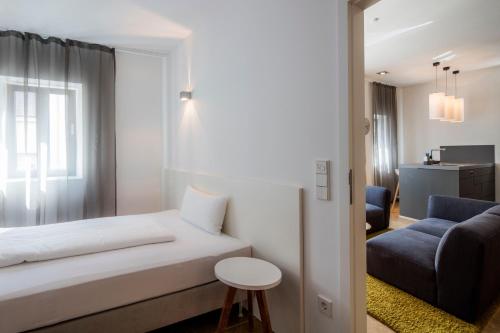 a bedroom with a bed and a couch and a chair at Loblocher Hof in Neustadt an der Weinstraße
