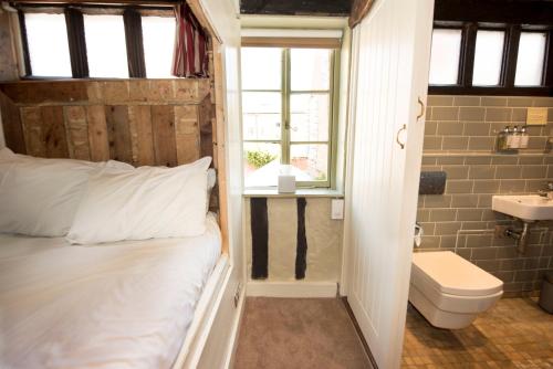 uma casa de banho com uma cama, um WC e um lavatório. em Alma Inn & Dining Rooms em Harwich