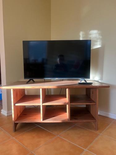 un centro di intrattenimento in legno con un grande televisore sopra di Beachside Apartment a Apollo Bay