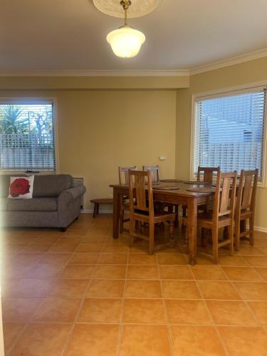 ein Esszimmer mit Tisch, Stühlen und Sofa in der Unterkunft Beachside Apartment in Apollo Bay