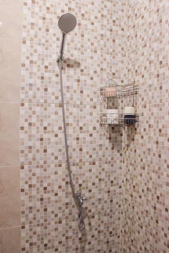 a shower in a bathroom with a tiled wall at Omah Poer Modern Tropical Villa in Giri