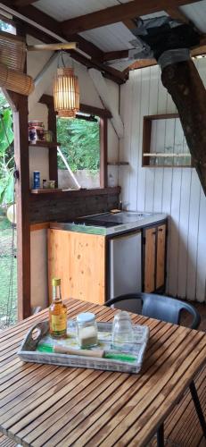 a wooden table in a kitchen with a tableablish at Bungalow atypique Ti Bambou à 500m de la plage in Sainte-Anne