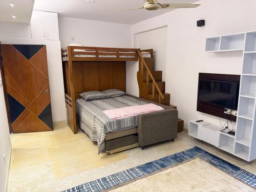a bedroom with a bunk bed and a flat screen tv at Modern Luxury Escape Balcony & Family Friendly in Dhaka