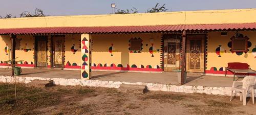 a building with a table and chairs in front of it at Rann Roshni homestay in Bherandiāla
