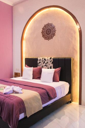 a bedroom with a large bed with an arch above it at Omah Poer Modern Tropical Villa in Giri