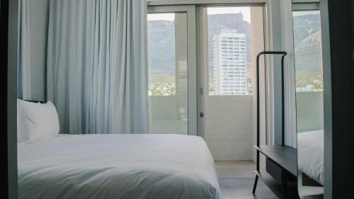 a hotel room with a bed and a window at BlackBrick Gardens in Cape Town