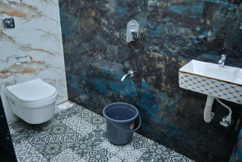 ein Badezimmer mit Toilette, Waschbecken und Mülleimer in der Unterkunft Kokan beach cottage in Alibag