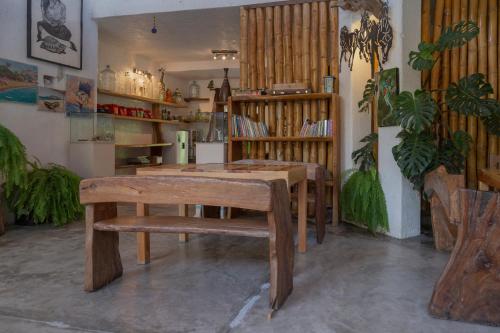 una mesa y un banco en una habitación con plantas en Hotel Casa Lasibe Café, en Santa Cruz Huatulco
