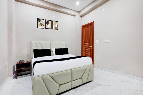 a white bedroom with a bed and a desk at Collection O Sector 33 Gurgaon in Gurgaon